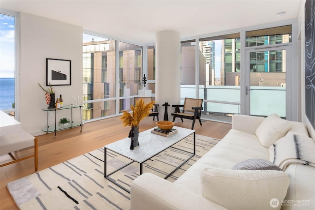 121 Stewart St Unit 1407, Seattle, WA 98101 - living area with a wall of windows, healthy amount of natural light, wood finished floors, and a water view