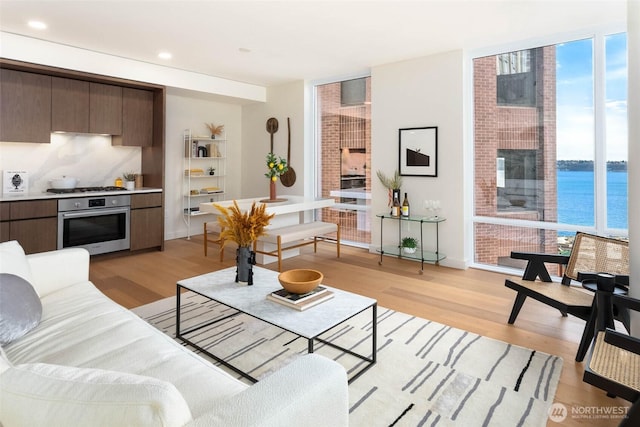 121 Stewart St Unit 1407, Seattle, WA 98101 - living area with floor to ceiling windows, light wood-style flooring, recessed lighting, and a water view
