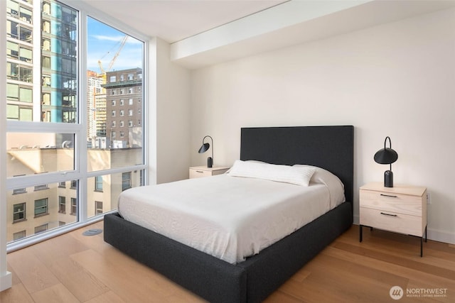 121 Stewart St Unit 1407, Seattle, WA 98101 - bedroom with wood finished floors, expansive windows, and a view of city