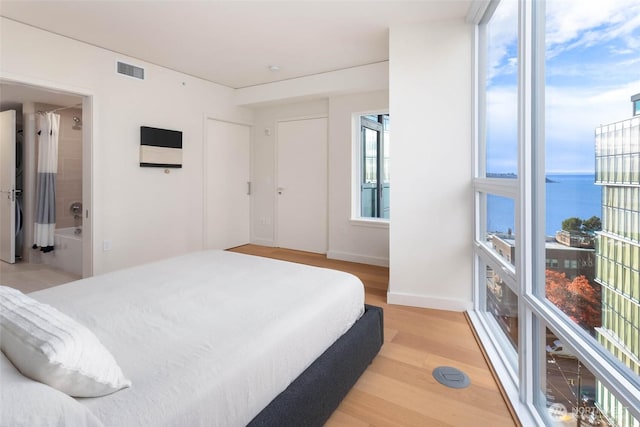 121 Stewart St Unit 1407, Seattle, WA 98101 - bedroom featuring light wood-type flooring and a water view