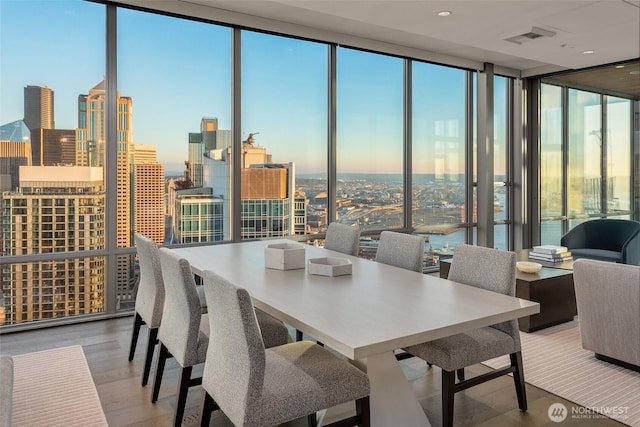 121 Stewart St Unit 1407, Seattle, WA 98101 - dining room featuring expansive windows, healthy amount of natural light, a view of skyline, and wood finished floors