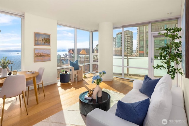 121 Stewart St Unit 1407, Seattle, WA 98101 - living room featuring a wall of windows, plenty of natural light, wood finished floors, and a view of city