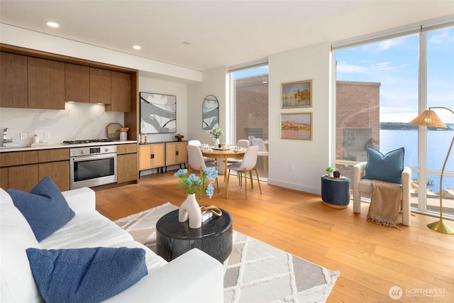121 Stewart St Unit 1407, Seattle, WA 98101 - living room featuring light wood-style floors, a wall of windows, and recessed lighting