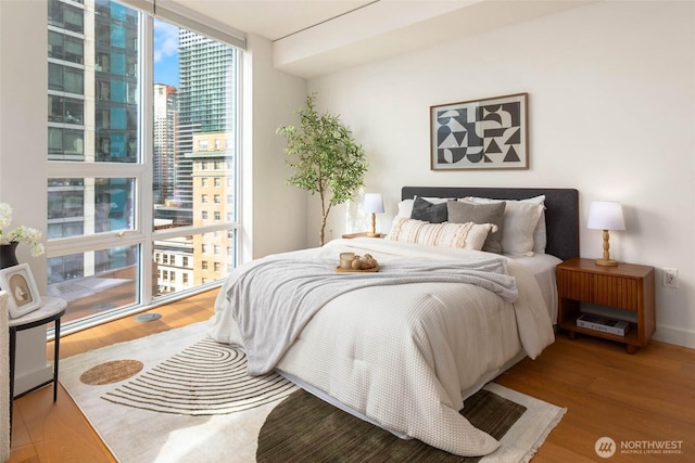 121 Stewart St Unit 1407, Seattle, WA 98101 - bedroom with a wall of windows and wood finished floors