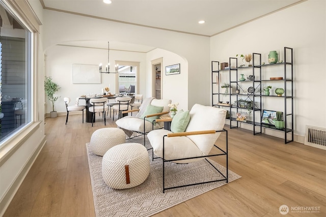702 34th St, Everett, WA 98201 - living room with arched walkways, light wood-style floors, a chandelier, recessed lighting, and ornamental molding