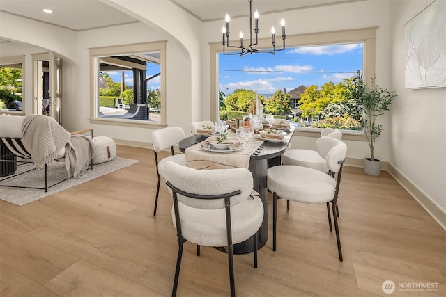 702 34th St, Everett, WA 98201 - dining area with arched walkways, light wood-type flooring, a chandelier, ornamental molding, and healthy amount of natural light