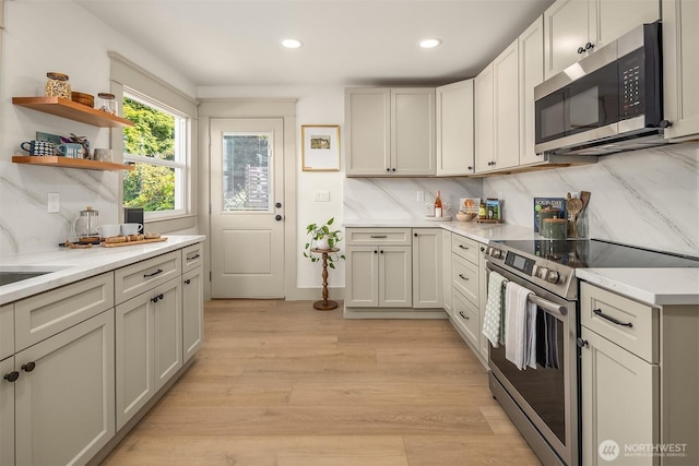 702 34th St, Everett, WA 98201 - kitchen with stainless steel appliances, light countertops, recessed lighting, light wood-style floors, and tasteful backsplash