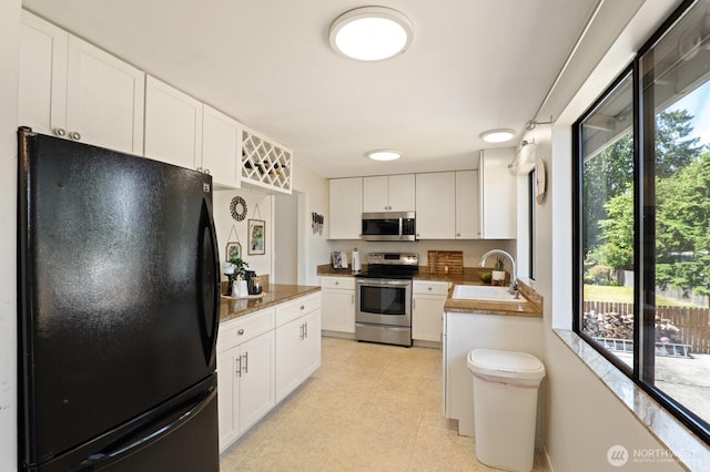8815 221st Pl SW, Edmonds, WA 98026 - kitchen with appliances with stainless steel finishes, white cabinets, and light tile patterned floors