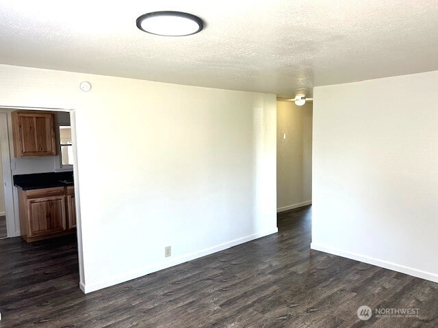 1004 8th, Longview, WA 98632 - unfurnished dining area with dark wood-style flooring and a textured ceiling