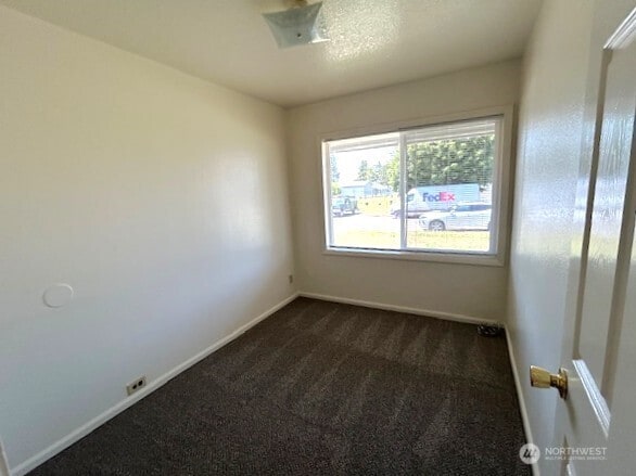1004 8th, Longview, WA 98632 - spare room with dark carpet and baseboards