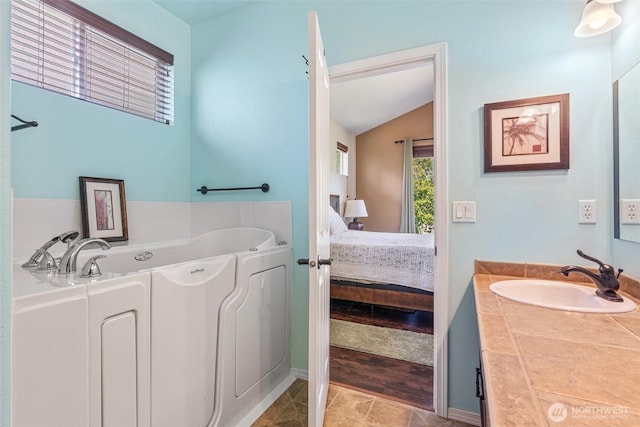 9127 Periwinkle Loop NE, Olympia, WA 98516 - ensuite bathroom with vanity, a garden tub, and lofted ceiling