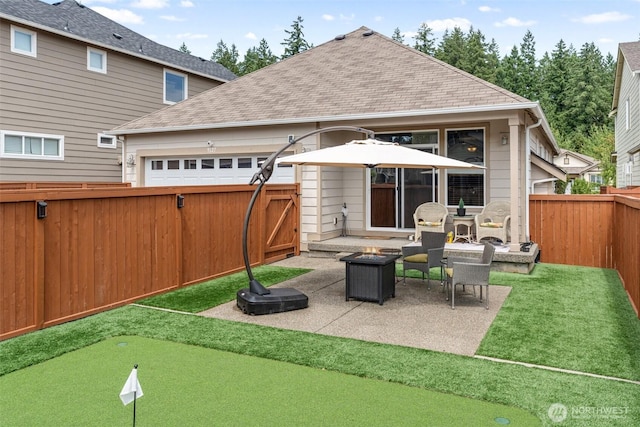 9127 Periwinkle Loop NE, Olympia, WA 98516 - rear view of house with a fire pit, a shingled roof, a fenced backyard, a patio, and an attached garage