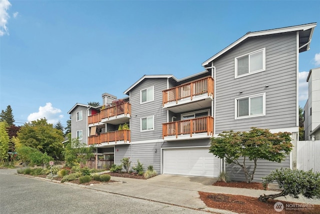7000 Cleopatra Pl NW Unit 303, Seattle, WA 98117 - view of front of house with an attached garage, concrete driveway, and a balcony