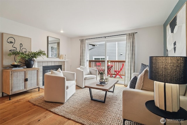 7000 Cleopatra Pl NW Unit 303, Seattle, WA 98117 - living area with wood finished floors, a tiled fireplace, and recessed lighting