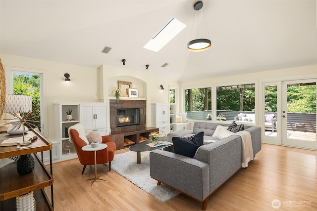 9201 24th Ave NW, Seattle, WA 98117 - living area with light wood-style flooring, a fireplace, a skylight, and high vaulted ceiling