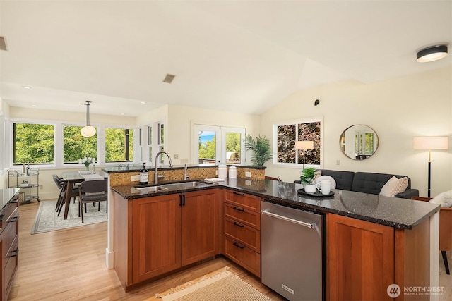 9201 24th Ave NW, Seattle, WA 98117 - kitchen with stainless steel dishwasher, light wood finished floors, dark stone counters, brown cabinets, and vaulted ceiling