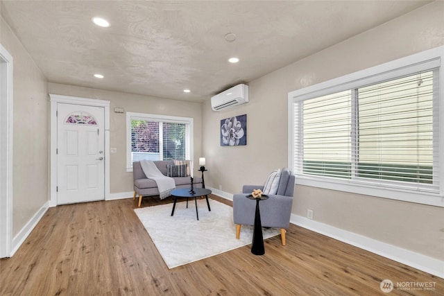 3109 N 7th St, Tacoma, WA 98406 - living area featuring an AC wall unit, light wood-style flooring, and recessed lighting