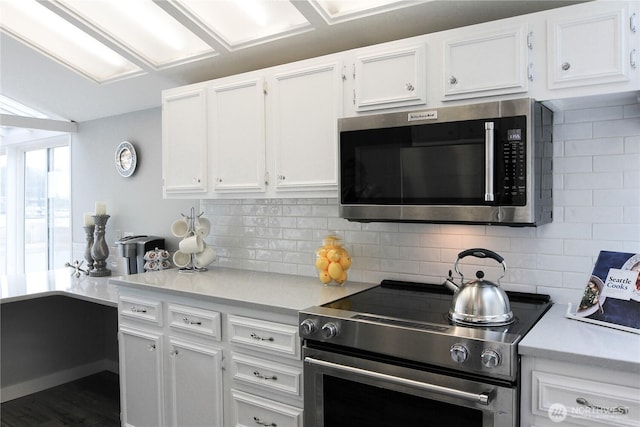2010 Waverly Pl N, Seattle, WA 98109 - kitchen featuring stainless steel appliances, white cabinets, light countertops, tasteful backsplash, and dark wood-style flooring