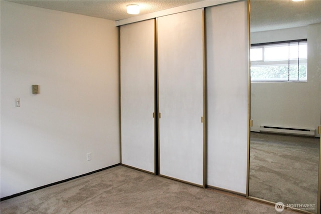 2010 Waverly Pl N, Seattle, WA 98109 - unfurnished bedroom featuring carpet, a baseboard heating unit, a closet, and a textured ceiling