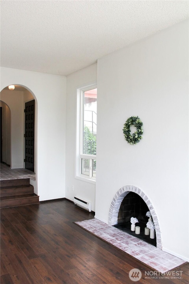 2010 Waverly Pl N, Seattle, WA 98109 - unfurnished living room with a baseboard radiator, wood finished floors, stairs, and a textured ceiling