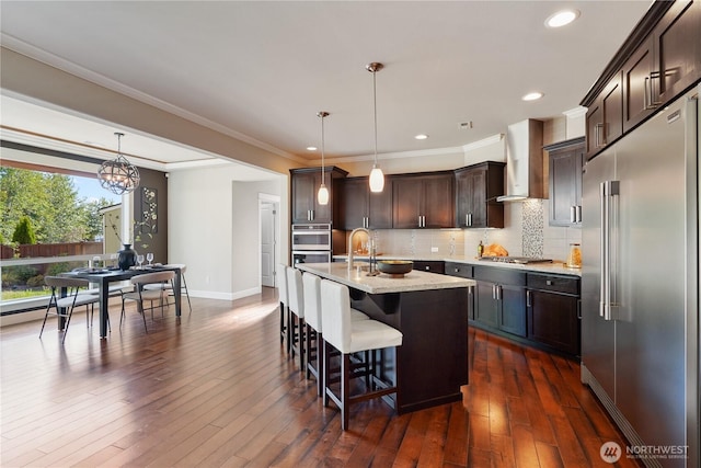 11214 172nd Street Ct E, Puyallup, WA 98374 - kitchen with stainless steel appliances, dark brown cabinets, a kitchen bar, decorative backsplash, and recessed lighting