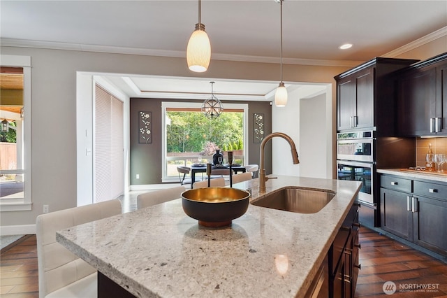 11214 172nd Street Ct E, Puyallup, WA 98374 - kitchen featuring dark wood-style flooring, double oven, ornamental molding, light stone counters, and pendant lighting