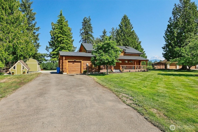 8209 271st Ave E, Buckley, WA 98321 - log cabin featuring a front yard, log exterior, asphalt driveway, a metal roof, and a porch