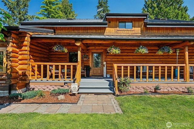8209 271st Ave E, Buckley, WA 98321 - view of front of home featuring a porch, a standing seam roof, a metal roof, and log exterior