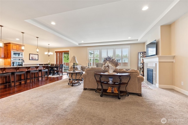 4837 Castleton Rd SW, Port Orchard, WA 98367 - carpeted living area featuring a tray ceiling, recessed lighting, a fireplace, and a chandelier