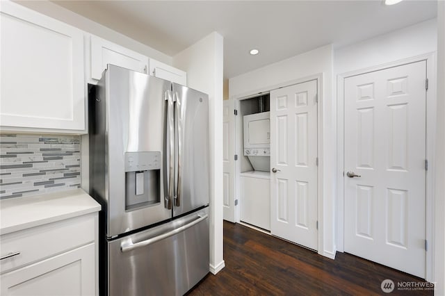 4026 Stone Way N Unit 501, Seattle, WA 98103 - kitchen with stainless steel refrigerator with ice dispenser, stacked washing machine and dryer, backsplash, white cabinets, and dark wood finished floors