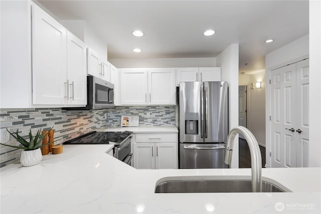 4026 Stone Way N Unit 501, Seattle, WA 98103 - kitchen with stainless steel appliances, white cabinets, backsplash, light stone countertops, and recessed lighting