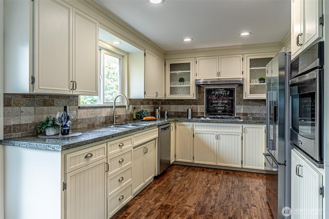 6301 Agnes Rd NE, Tacoma, WA 98422 - kitchen with appliances with stainless steel finishes, backsplash, dark wood-style flooring, glass insert cabinets, and under cabinet range hood