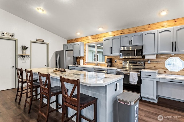 550 Red Tail Rd, Yakima, WA 98908 - kitchen featuring stainless steel appliances, vaulted ceiling, gray cabinets, dark wood-type flooring, and decorative backsplash