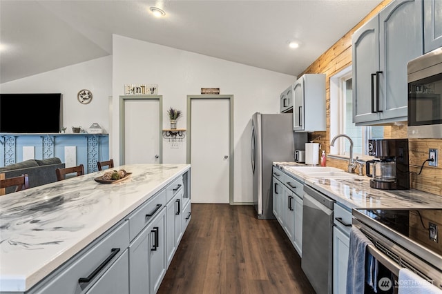 550 Red Tail Rd, Yakima, WA 98908 - kitchen featuring appliances with stainless steel finishes, lofted ceiling, light stone countertops, dark wood finished floors, and gray cabinetry