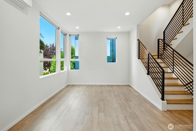 9732 Woodlawn Ave N Unit A, Seattle, WA 98103 - spare room featuring a wall unit AC, stairway, wood finished floors, and recessed lighting
