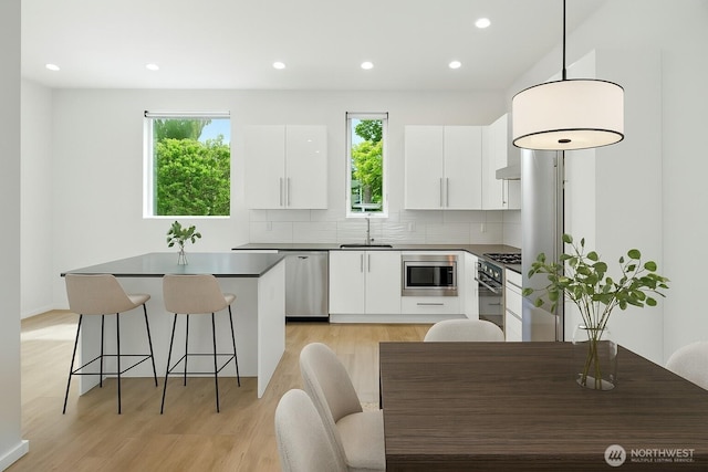 9732 Woodlawn Ave N Unit A, Seattle, WA 98103 - kitchen featuring dark countertops, a kitchen island, white cabinets, modern cabinets, and recessed lighting