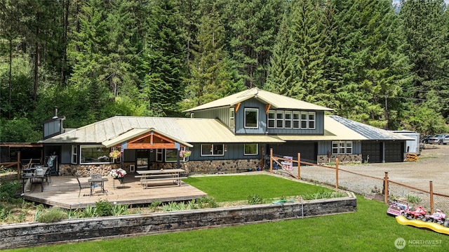 330 Swauk Creek Ln, Cle Elum, WA 98922 - back of house with stone siding, driveway, a deck, and a forest view