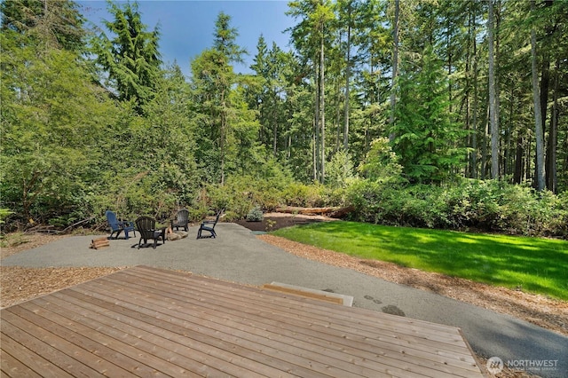 10405 Tahoma Dr, Anderson Island, WA 98303 - wooden deck featuring a patio area, a fire pit, a yard, and a wooded view