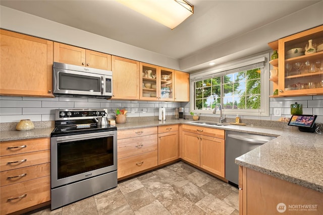 2714 Alderwood Ave, Bellingham, WA 98225 - kitchen featuring appliances with stainless steel finishes, backsplash, light brown cabinets, stone finish flooring, and glass insert cabinets
