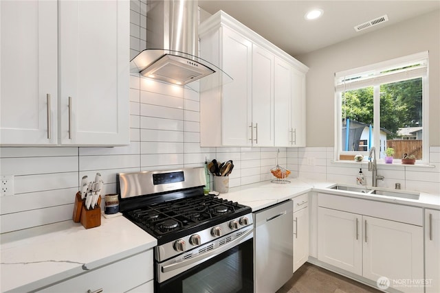 8438 Tacoma Ave S, Tacoma, WA 98444 - kitchen featuring stainless steel appliances, wall chimney range hood, white cabinetry, decorative backsplash, and light stone counters