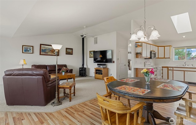 19627 Rd A NE, Soap Lake, WA 98851 - dining space with vaulted ceiling, a chandelier, light wood-style flooring, a skylight, and a ceiling fan