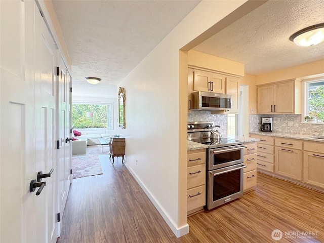 1521 W 13th St, Port Angeles, WA 98363 - kitchen featuring stainless steel appliances, a textured ceiling, light brown cabinets, light wood-style flooring, and tasteful backsplash