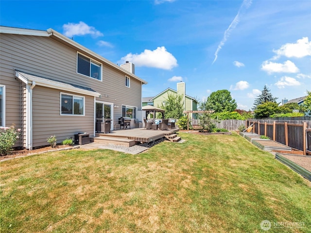 535 Blanchat Ct, Enumclaw, WA 98022 - back of property featuring a fenced backyard, a wooden deck, a chimney, and a garden