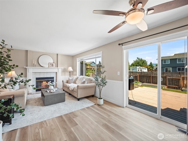 535 Blanchat Ct, Enumclaw, WA 98022 - living room with a tile fireplace, wood finished floors, wainscoting, and ceiling fan