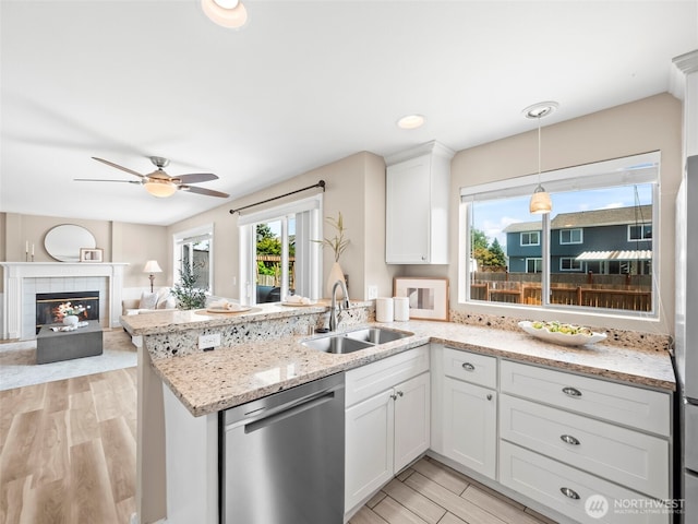535 Blanchat Ct, Enumclaw, WA 98022 - kitchen with stainless steel dishwasher, a ceiling fan, a peninsula, light wood-style flooring, and white cabinets