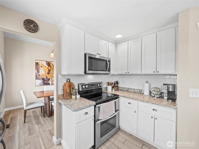 535 Blanchat Ct, Enumclaw, WA 98022 - kitchen with appliances with stainless steel finishes, light wood-type flooring, white cabinets, and tasteful backsplash