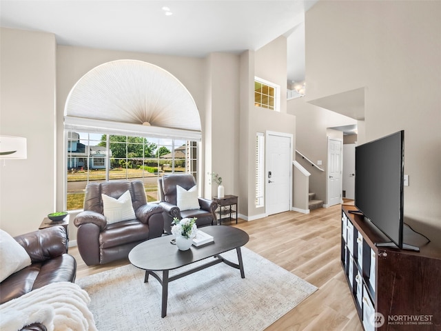 535 Blanchat Ct, Enumclaw, WA 98022 - living room featuring light wood-style flooring, stairs, and a towering ceiling