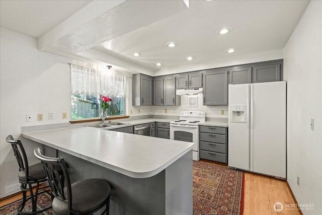 13319 15th Avenue Ct E, Tacoma, WA 98445 - kitchen with white appliances, under cabinet range hood, a peninsula, gray cabinets, and light countertops