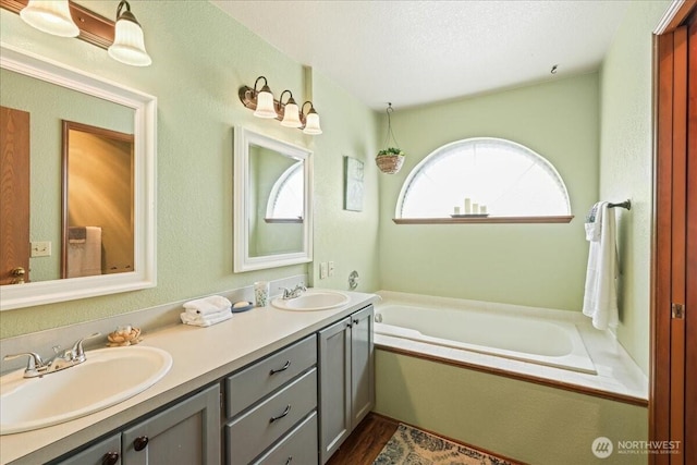 13319 15th Avenue Ct E, Tacoma, WA 98445 - bathroom featuring double vanity, a bath, and wood finished floors