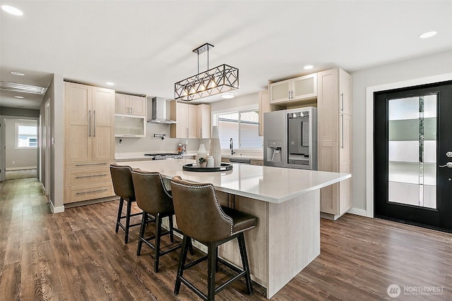 22526 251st Ave SE, Maple Valley, WA 98038 - kitchen with wall chimney range hood, fridge with ice dispenser, light countertops, a kitchen island, and dark wood-type flooring